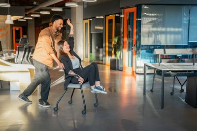 Colleagues celebrating in a hybrid office that uses smart desk booking